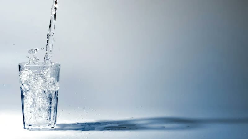 Water pouring into a clear glass